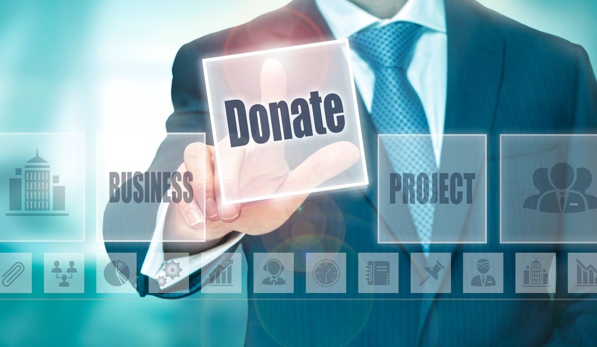 A businessman selecting a Donate Concept button on a clear screen.